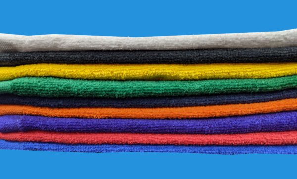 Stack of Different Color Towels on Blue Background