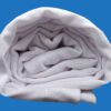 A White Towel Rolled Side View Shot on Blue Background