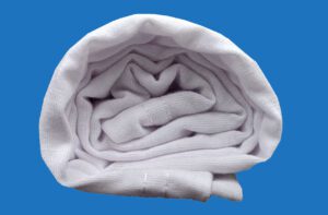 A White Towel Rolled Side View Shot on Blue Background