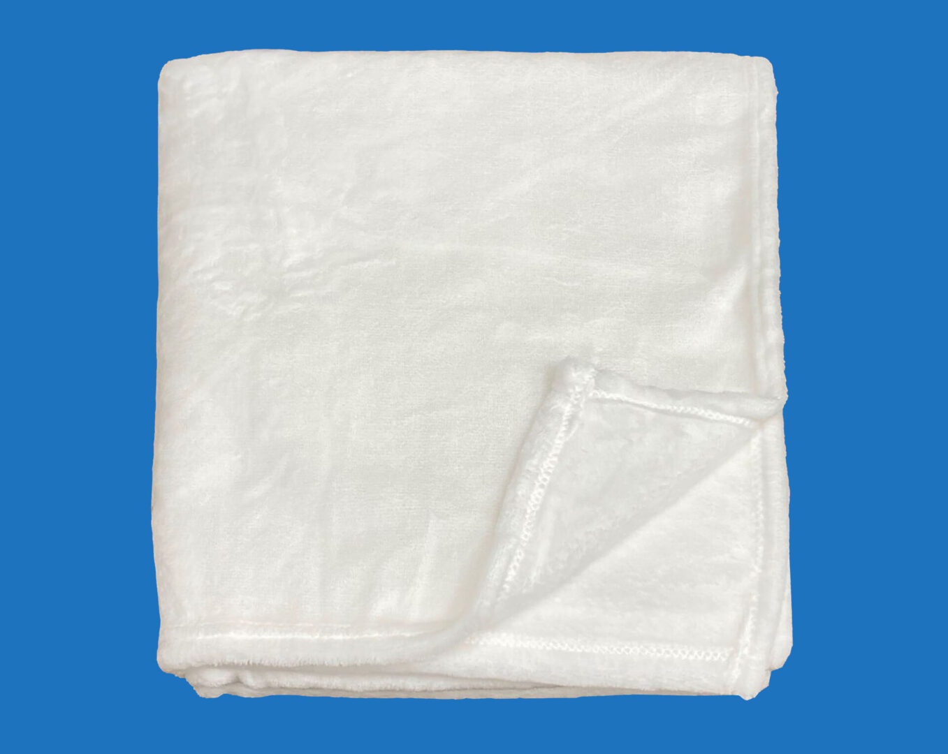 A Folded White Fluffy Blanket With Stitched Edges